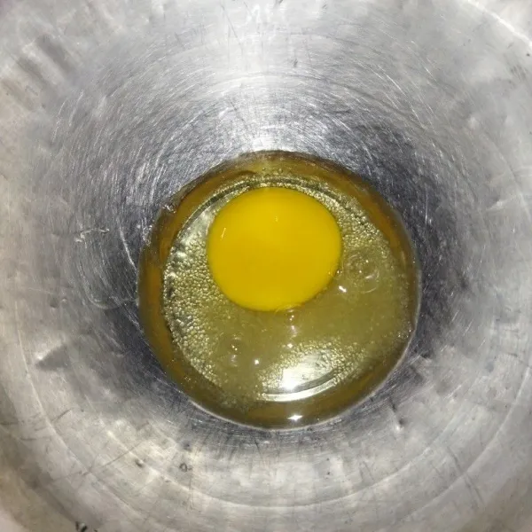 Siapkan wadah, masukkan telur dan gula pasir, lalu kocok hingga berbusa.