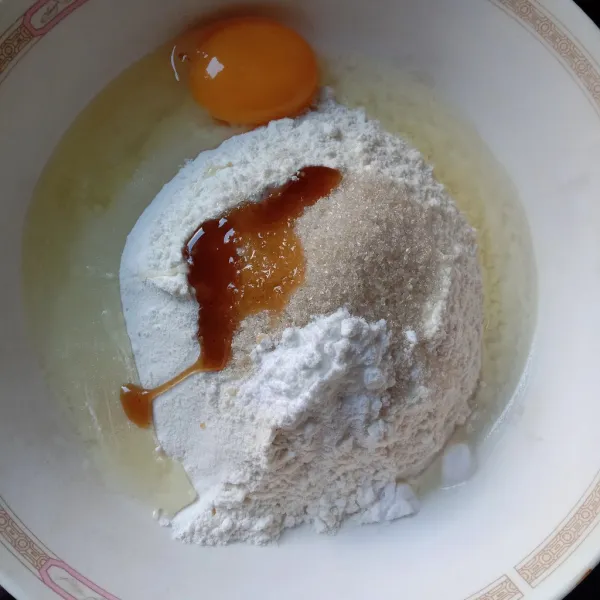 Dalam sebuah wadah, masukkan tepung terigu, gula, baking powder, vanilla paste, dan telur.
