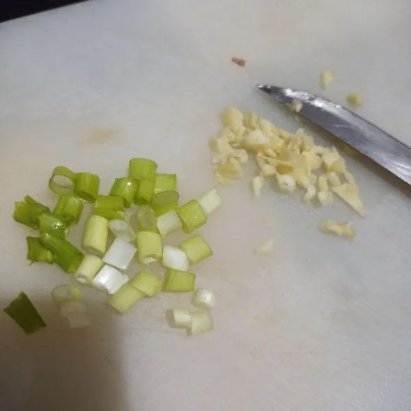 Rajang halus bawang putih, lalu rajang daun bawang.