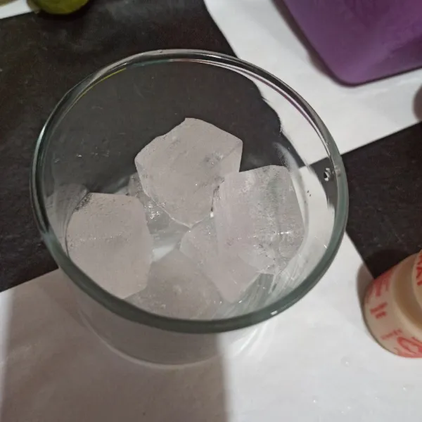 Masukkan es batu ke gelas.