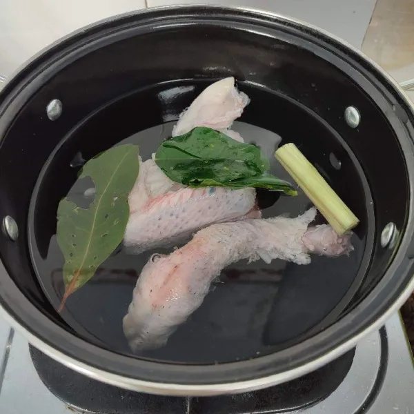 Kemudian rebus ayam dengan 1 liter air, daun salam, serai, dan daun jeruk purut hingga empuk.