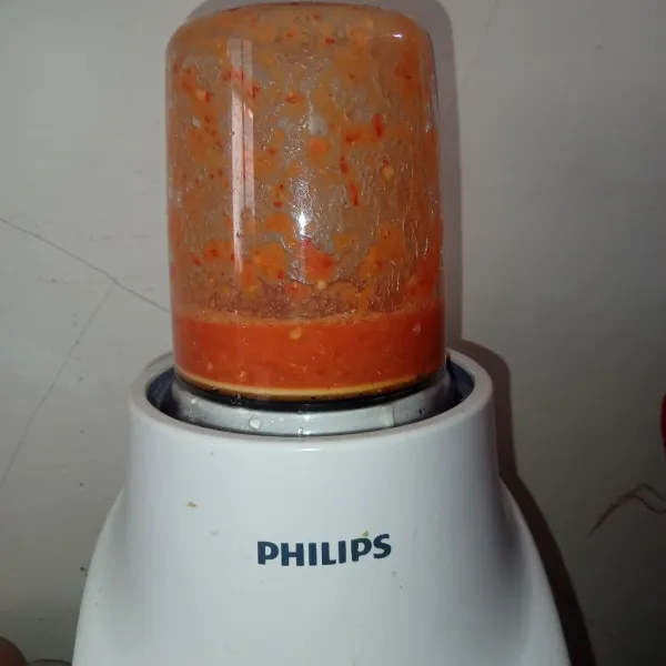 Blender cabai rawit dan bawang putih hingga halus.