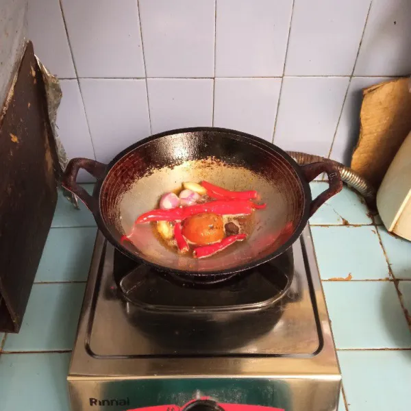Panaskan minyak, goreng bawang merah, bawang putih, cabe merah, tomat, dan terasi. Tumis hingga setengah matang. Angkat dan tiriskan.