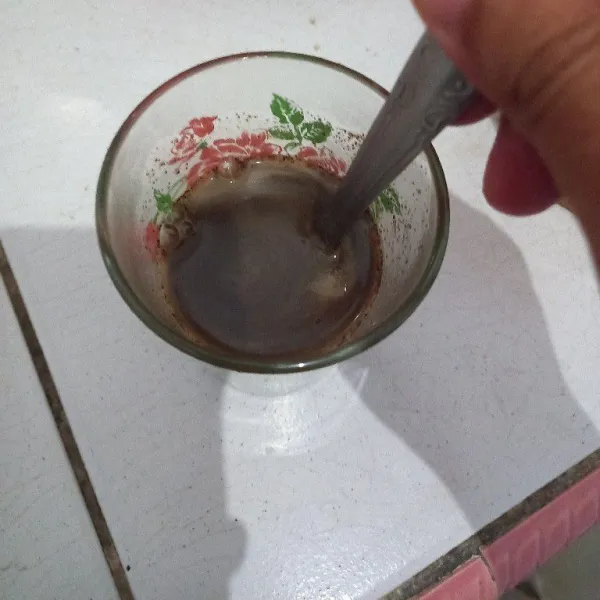 Tuang air yang sudah mendidih ke dalam gelas yang berisi kopi.