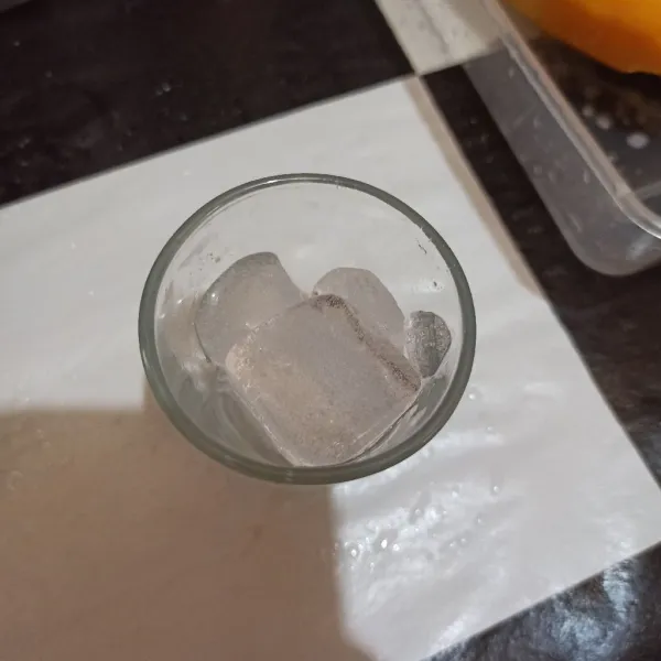 Masukkan es batu ke gelas.