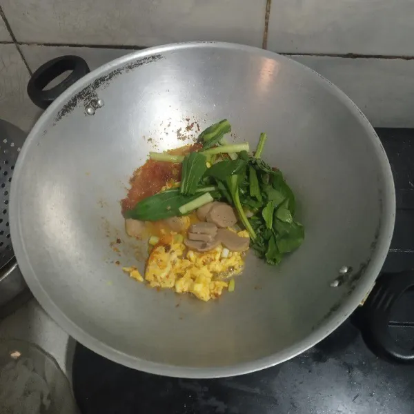 Masukan telur kocok, sawi, daun bawang dan bakso. Aduk rata.