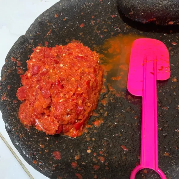 Giling cabe merah keriting dengan bawang merah, garam, dan tomat.