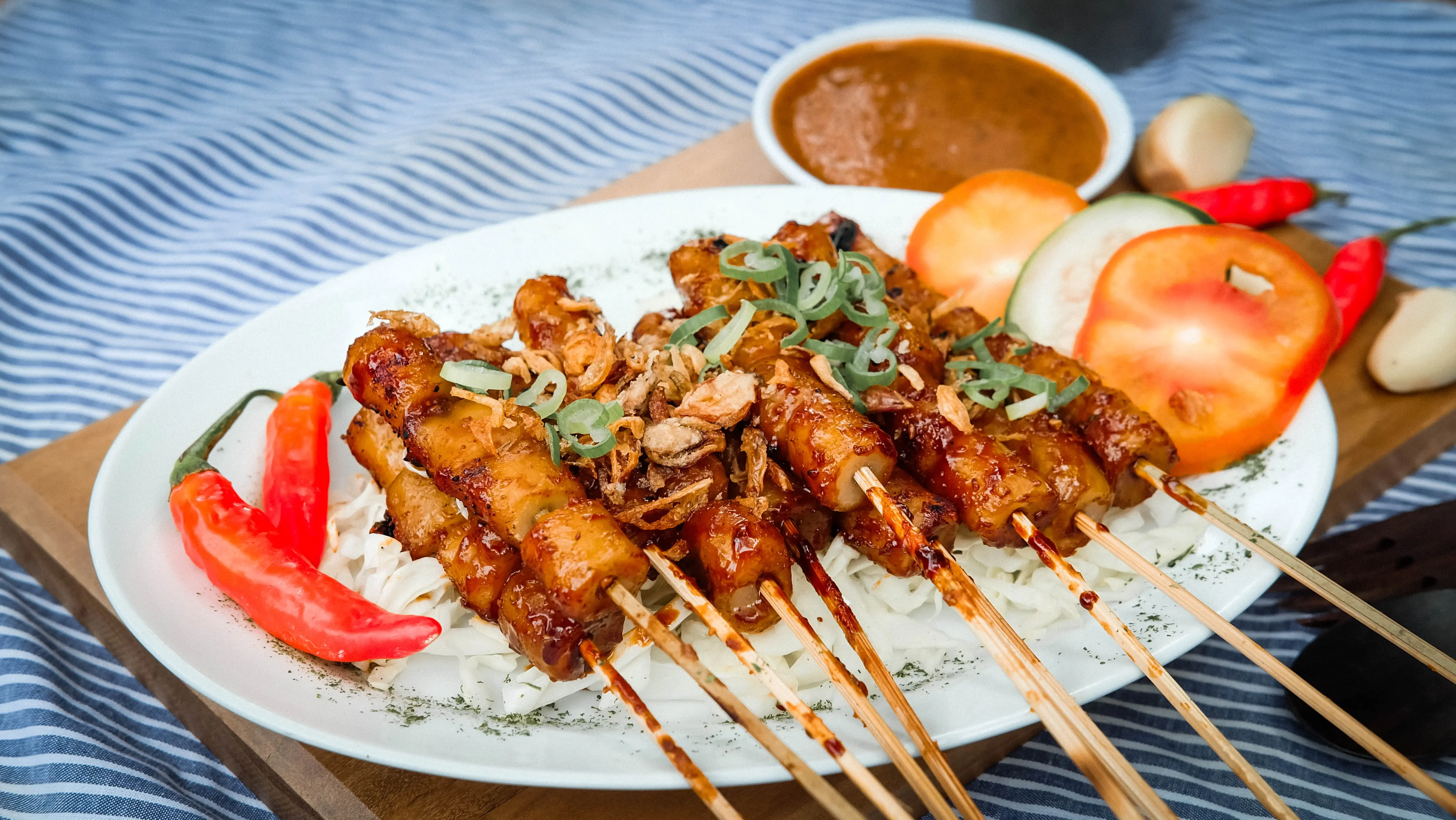 Sate dengan bumbu kacang dan taburan bawang goreng