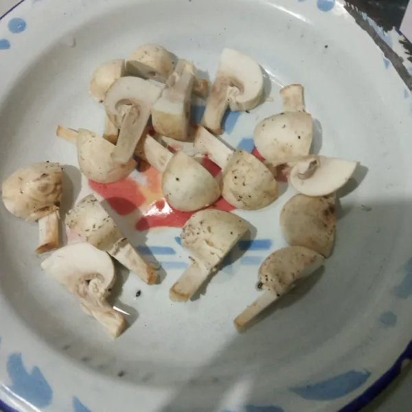 Potong jamur kancing menjadi 4 bagian.