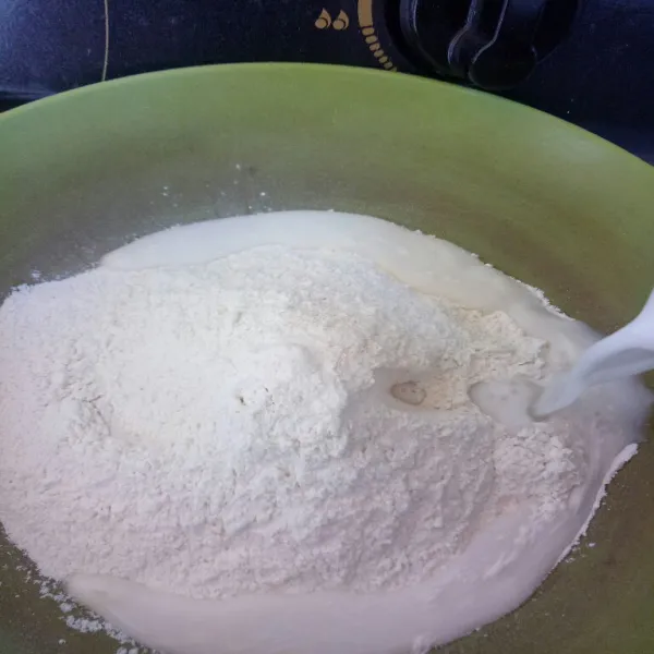 Masukan adonan tepung, gula pasir, vanilli, dan garam kedalam wadah lalu tuang santan.