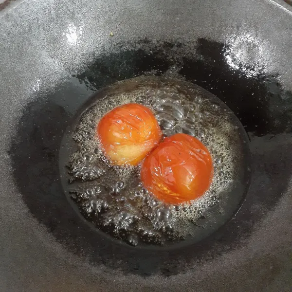 Panaskan minyak sayur dengan api sedang, goreng tomat hingga layu.