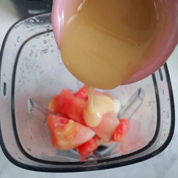 Masukan potongan semangka ke dalam blender dan tambahkan krimer kental manis.