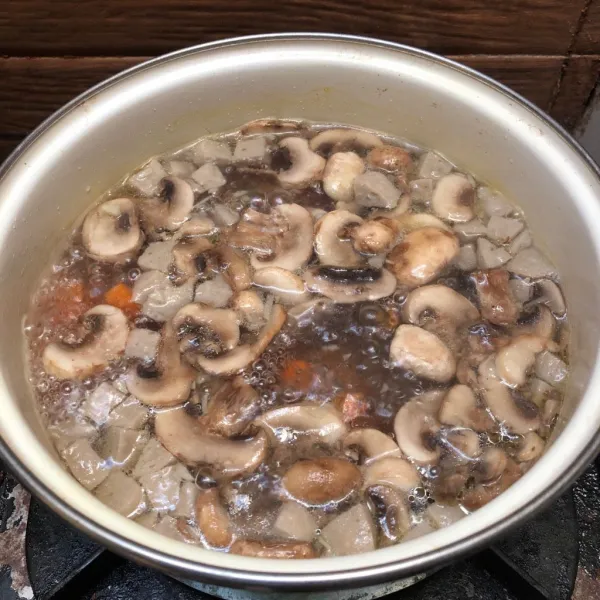 Masukkan tumisan jamur dan bawang putih ke air rebusan wortel dan bakso.