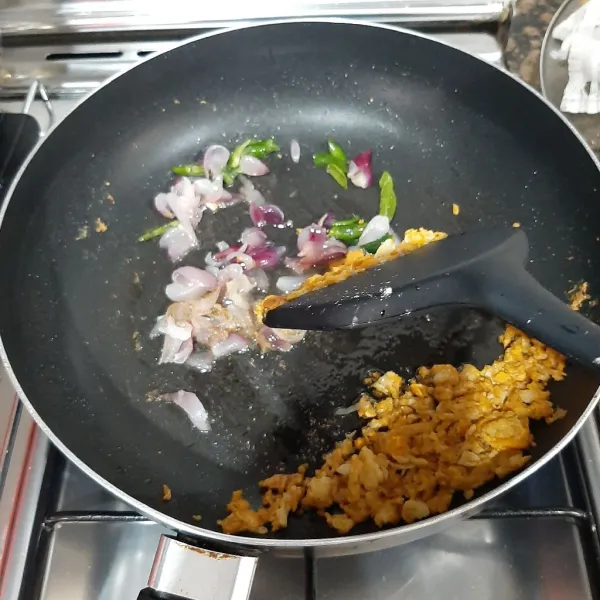 Sisihkan telur orek ke pinggir pan, tambahkan minyak sisa goreng ayam secukupnya, tumis bawang merah dan cabe iris hingga harum.