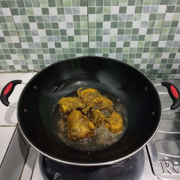 Goreng ayam dalam minyak panas hingga kecoklatan, lalu angkat dan tiriskan.