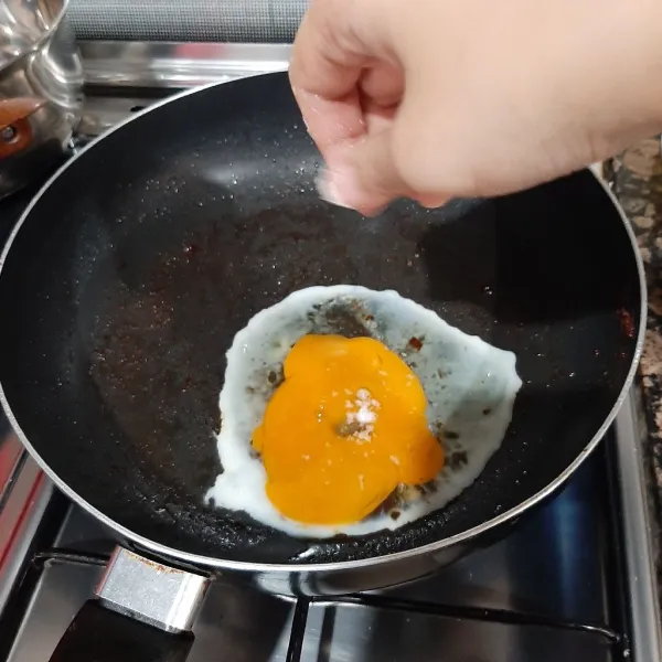 Pindahkan minyak sisa goreng ayam, kemudian masukan telur ke pan tersebut tambah sejumput garam, orek hingga agak kering