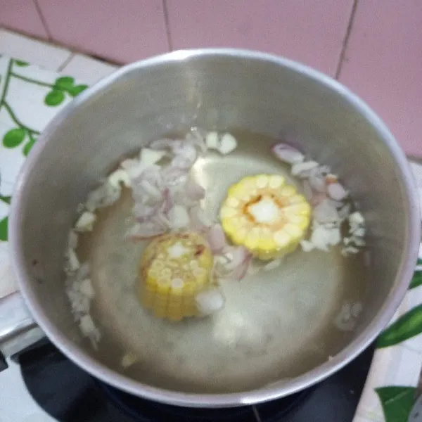 Didihkan air, masukkan bawang merah dan bawang putih kemudian masukkan jagung rebus sampai jagung matang.