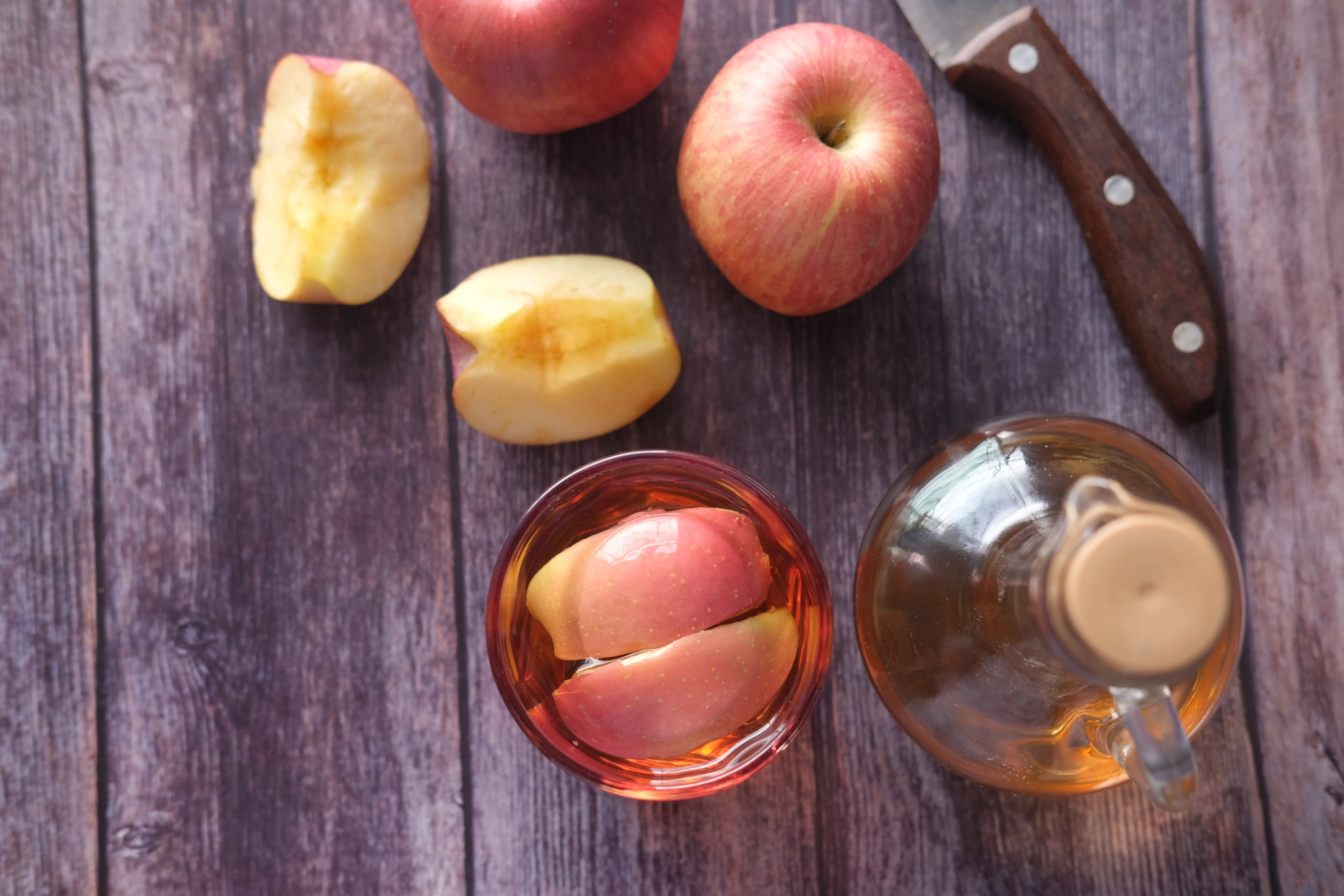 Cuka apel yang disimpan di dalam gelas dan botol kaca