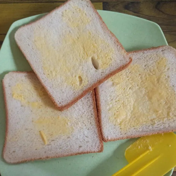 Olesi setiap bagian roti tawar dengan margarin.
