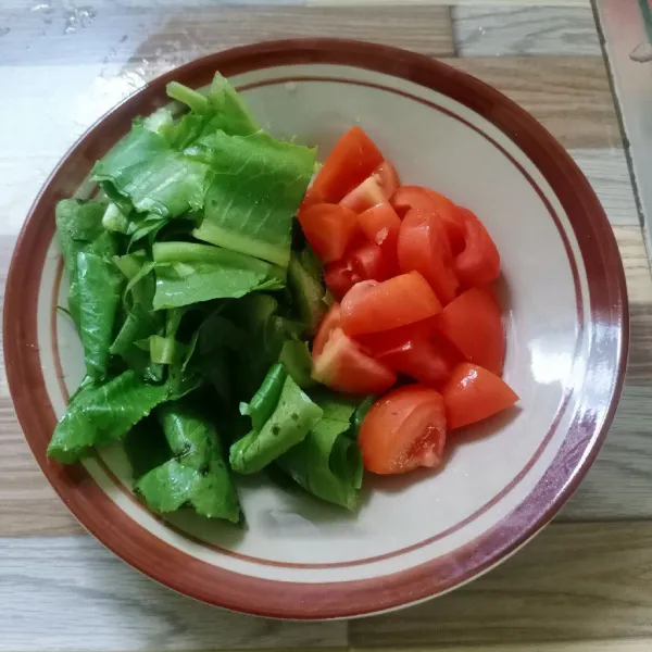 Potong-potong tomat dan selada.
