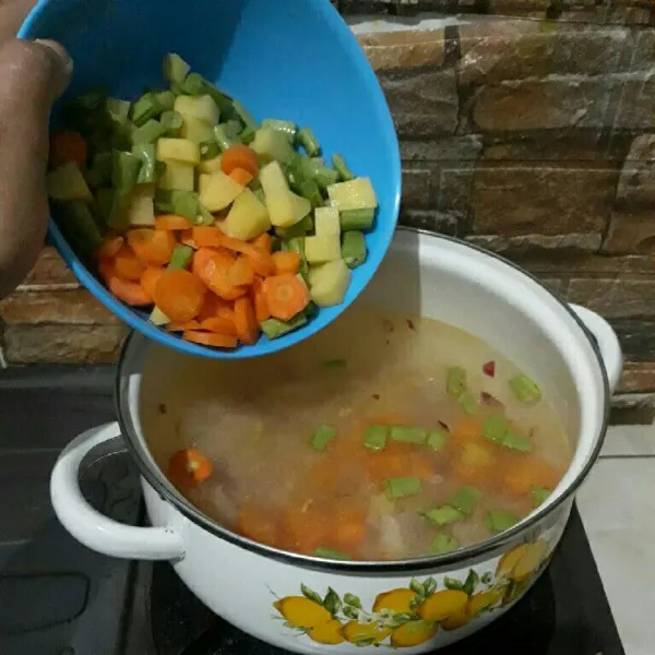 Tuangkan air kaldu. Masukkan wortel, buncis, kentang, jagung manis, masak hingga sayur matang.