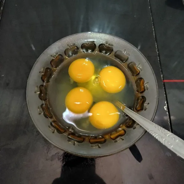Siapkan telur, lalu pecahkan dalam mangkuk. Kemudian kocok lepas.