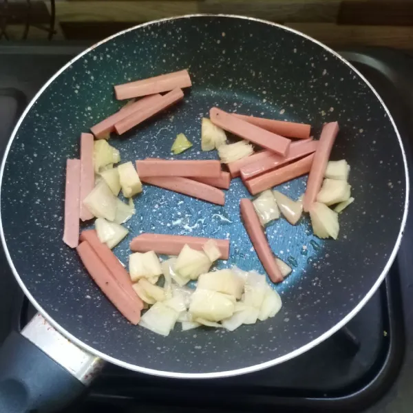 Tumis bawang bombai dan sosis sampai matang.