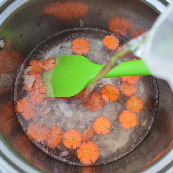 Masukkan wortel dan air, rebus hingga wortel empuk.