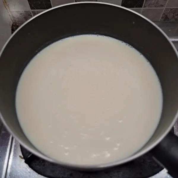 Rebus susu dan vanilla essence sampai keluar gelembung kecil di tepi panci.