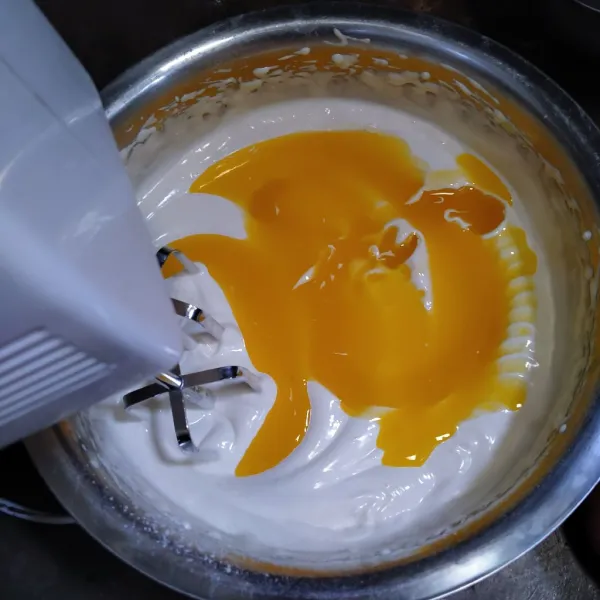Setelah adonan mengembang, masukka margarin cair dan pewarna kuning lalu aduk rata.