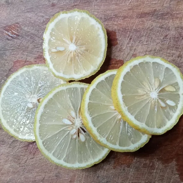 Cuci bersih lemon, lalu potong-potong.