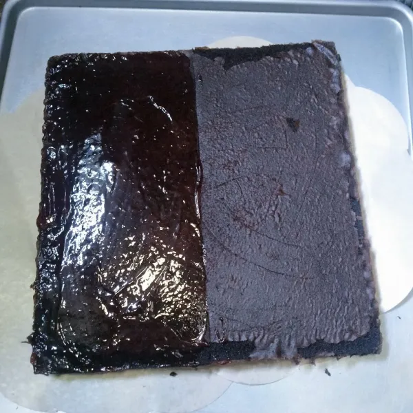 Keluarkan dari loyang lalu potong 2 sama rata. Olesi salah satu permukaan cake dengan selai coklat lalu timpa dengan cake yang lainnya.