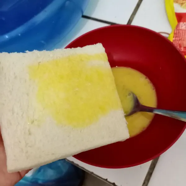 Rendam roti dalam telur di kedua sisinya.