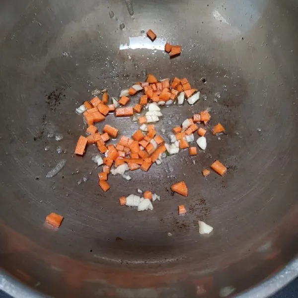 Tumis bawang putih dan wortel hingga harum dan layu.