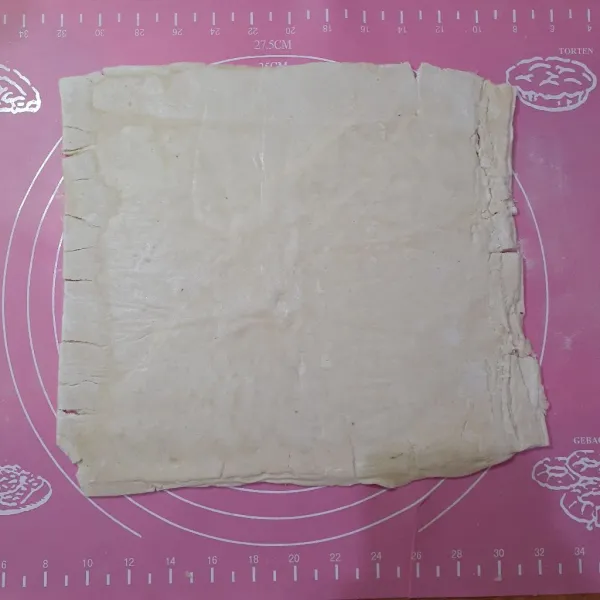 Tipiskan sedikit kulit puff pastry dengan bantuan rolling pin.