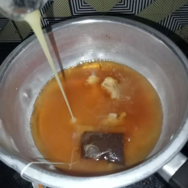 Tuang krimer kental manis secukupnya sampai air teh terasa manis.