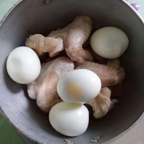 Tata daun salam, lengkuas, serai, nangka muda, ayam, dan telur dalam panci.