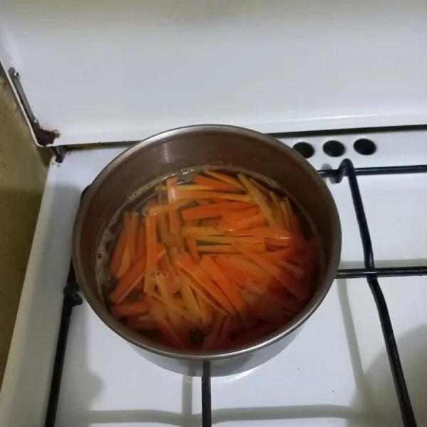 Rebus irisan korek wortel hingga setengah matang, tiriskan.