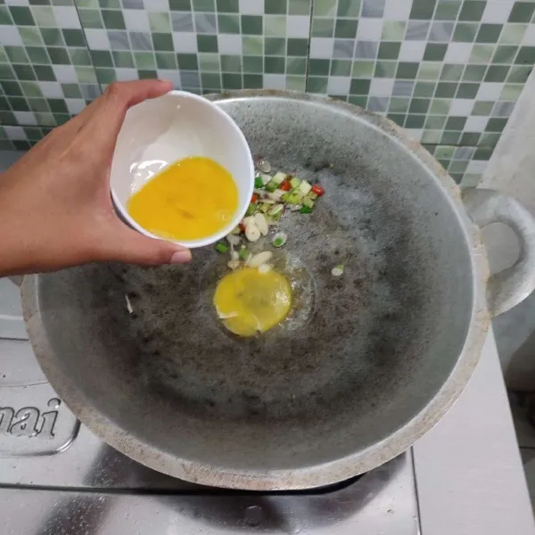 Sisihkan tumisan bawang ke pinggir wajan, lalu masukkan kocokan telur.