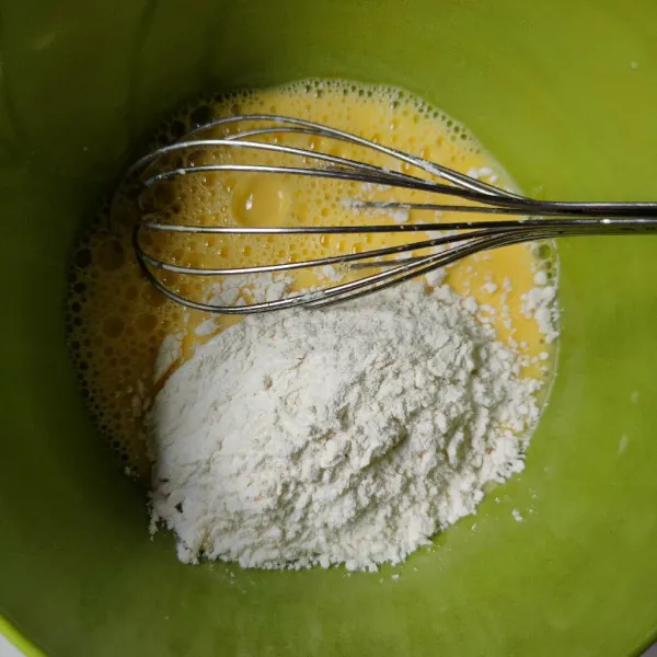Masukkan tepung terigu dan baking powder, whisk hingga tercampur rata.