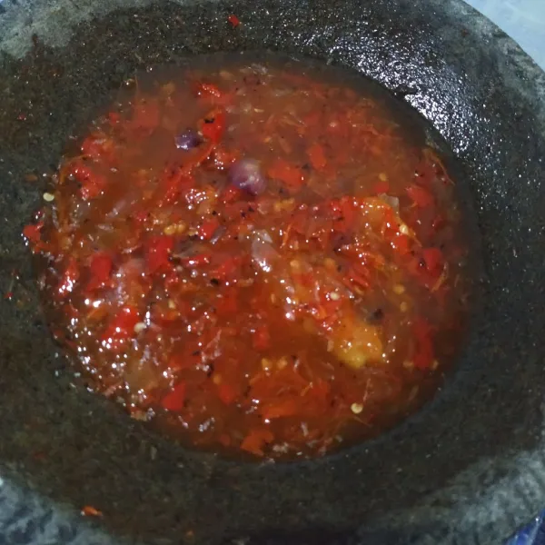 Aduk rata sambal pecak. Lalu siram ke atas Ikan Nila goreng. Pecak Ikan Nila Khas Betawi siap disajikan.