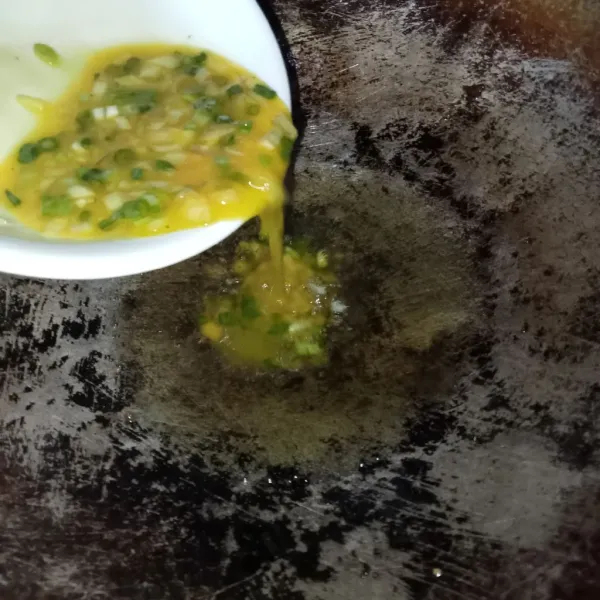 Panaskan minyak goreng yang cukup banyak agar telur dadar jadi gimbal, lalu tuang kocokan telur.