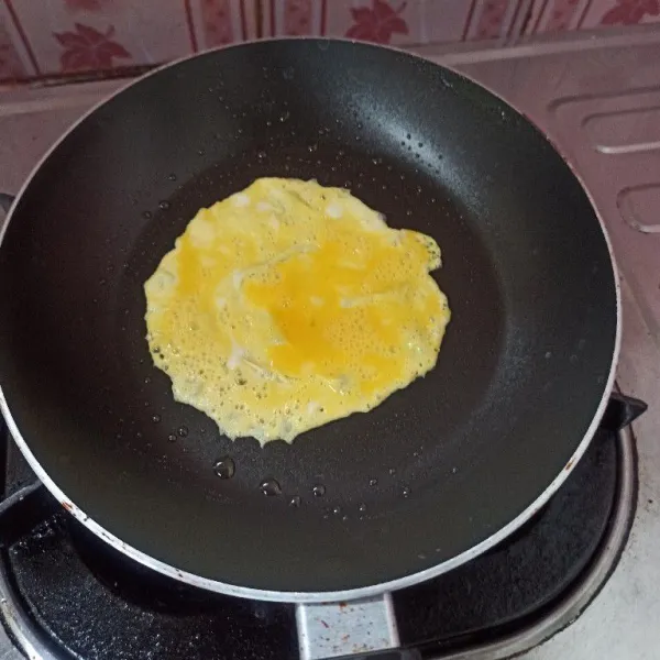 Olesi teflon dengan sedikit minyak goreng, kemudian tuang satu sendok makan telur.