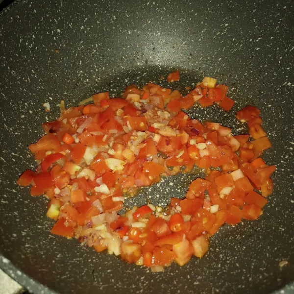 Masukkan potongan tomat dan cabe rawit, masak sampai layu.