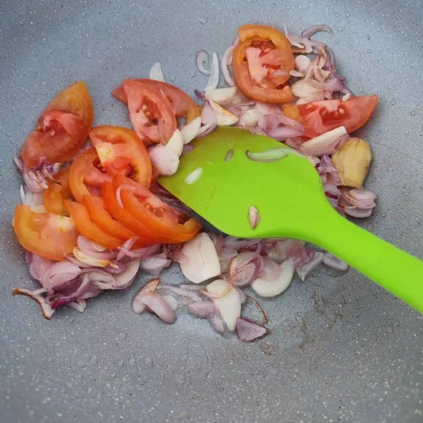 Masukkan potongan tomat, tumis hingga layu.