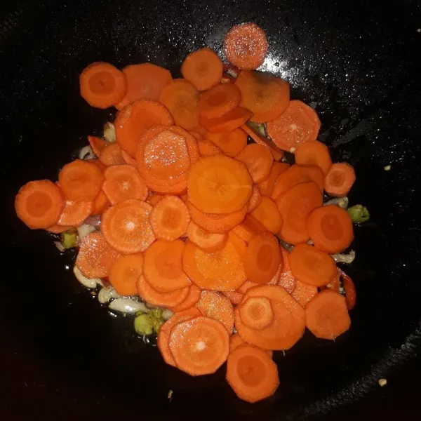 Masukkan wortel, aduk-aduk sampai layu. Tambahkan air lalu masak hingga mendidih.