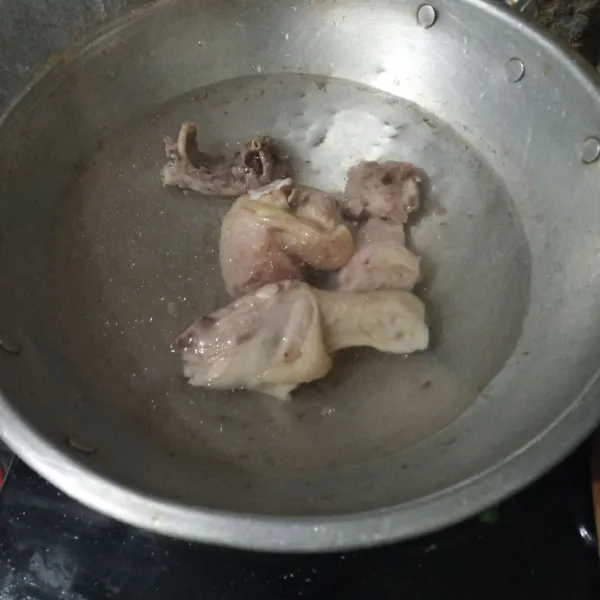 Rebus ayam selama 5 menit, buang airnya dan rebus kembali dengan api kecil.