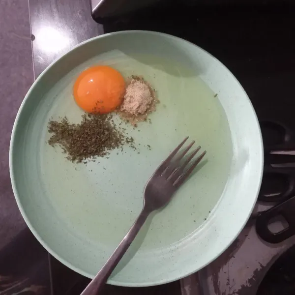 Masukkan telur ke dalam piring, tambahkan bumbu mie instan dan parsley, aduk rata.