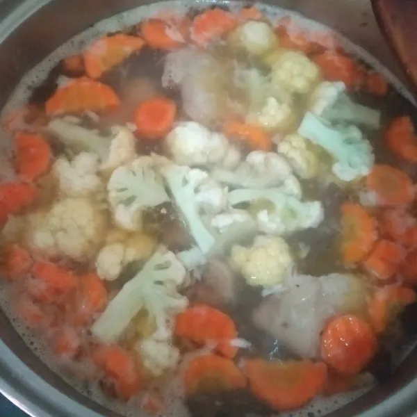 Lalu tambakan wortel, kentang dan kembang kol yang sudah dipotong potong, masak hingga sayuran setengah matang.