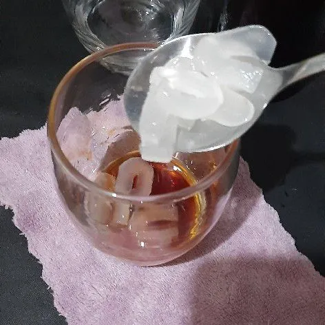 Tuang sirup gula dan potongan siwalan ke dalam gelas.